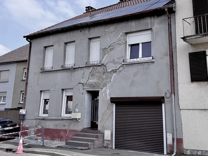 Cocheren avant travaux : façade grise fissurée, enduit décollé et soubassement abîmé