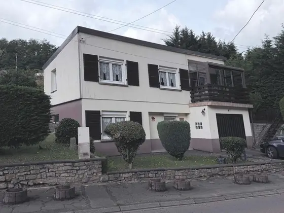 Betting avant travaux : façades blanches, volets sombres et soubassement mauve