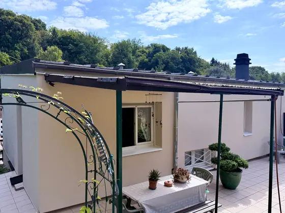 Betting après travaux, côté terrasse : enduit beige lisse sous la pergola