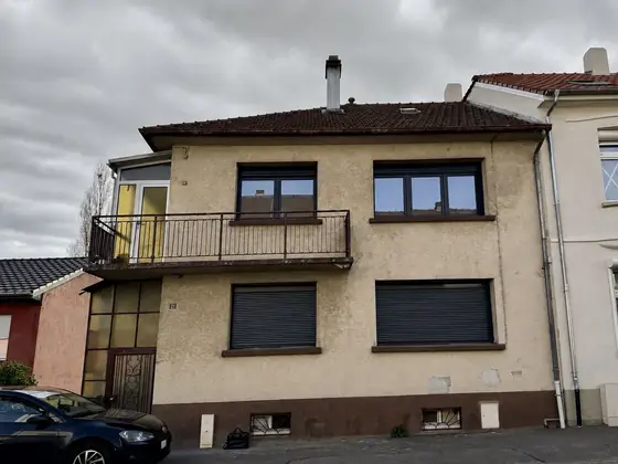 Freyming-Merlebach, maison mitoyenne avant travaux : crépi beige usé, véranda et soubassement brun